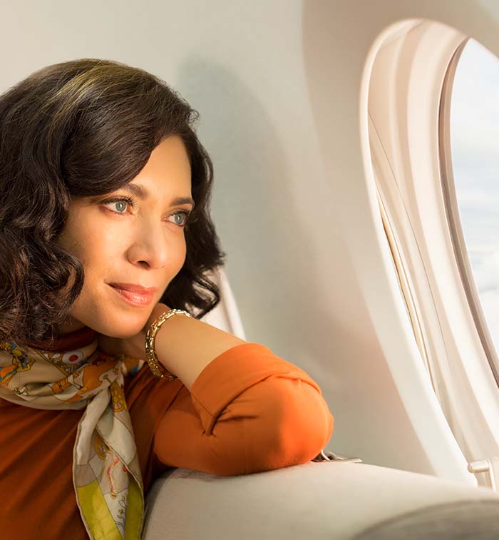 Woman looking out a G280 window with gentle sunlight on her face