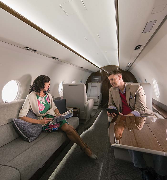 Man and woman talking in a bright G280 cabin