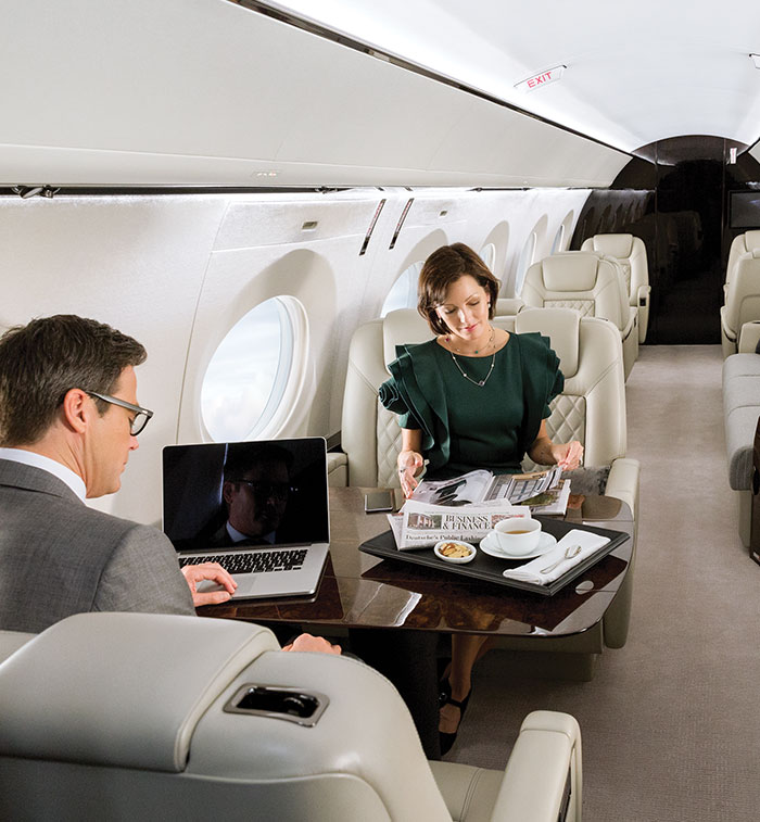 Man and woman work and dine in a bright G500 cabin