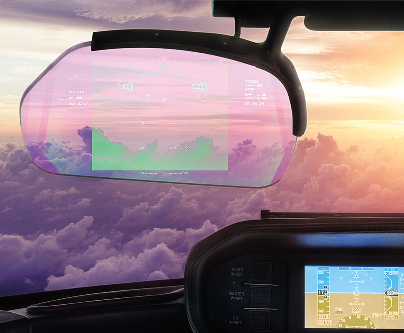 Close up view of the heads up display showing flying data over the window view of a cloudy sunset sky