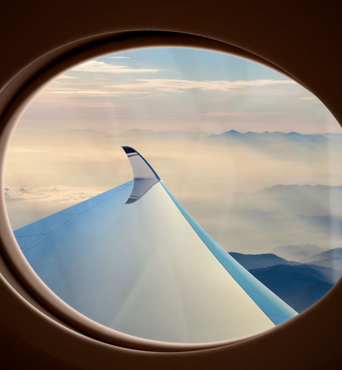Looking through a large oval window at the port-side wing and winglet